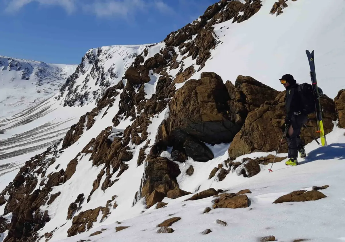 skier looking over a steep slope in Newfoundland backcountry