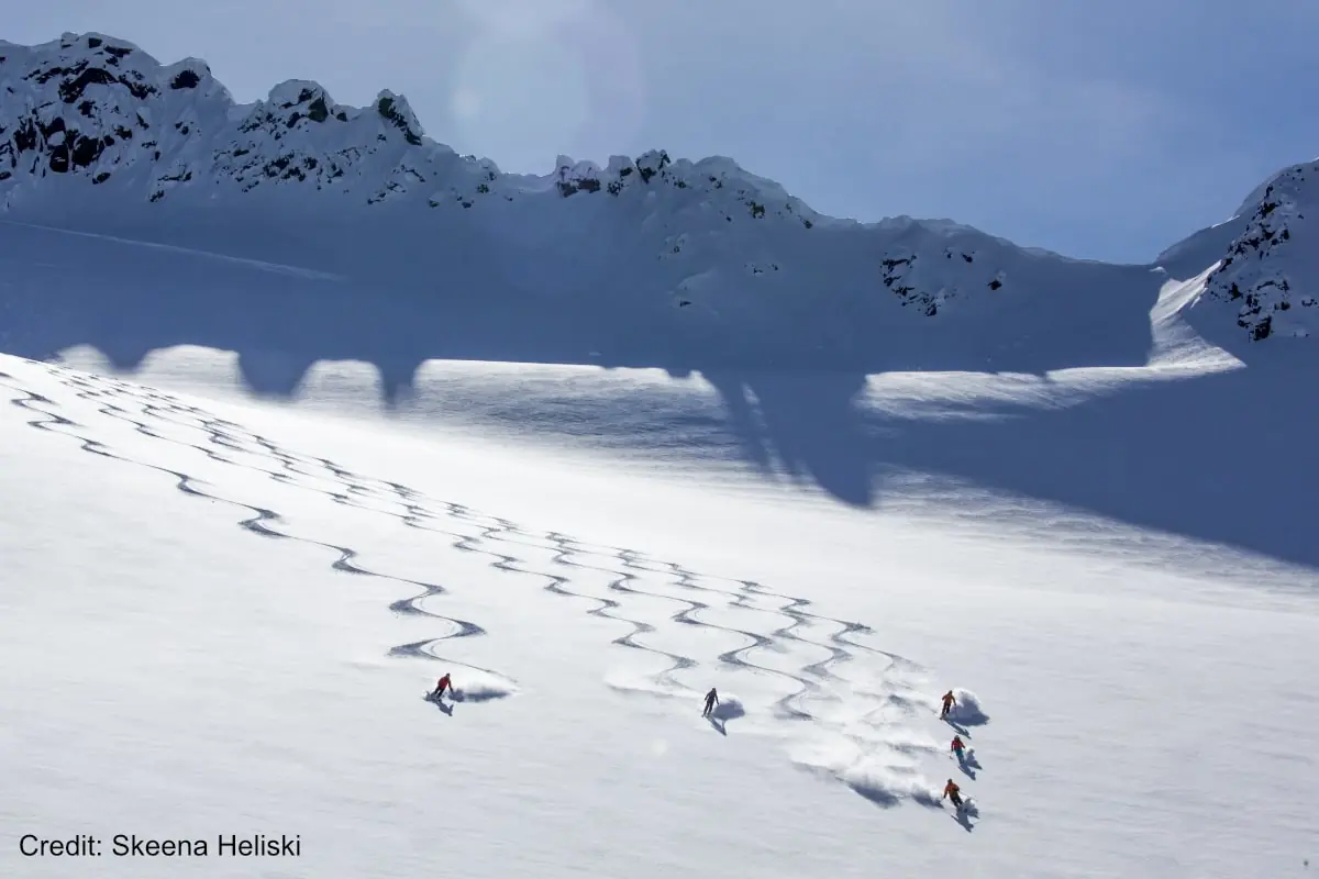 group of skiers getting fresh tracks on a heli ski tour