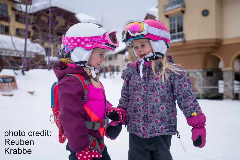 two young girls outside in the snow of Sun Peaks village
