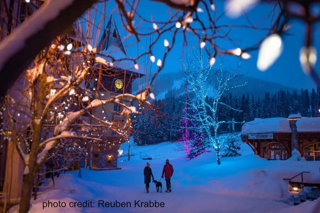 couple walking their dog through Sun Peaks village at night