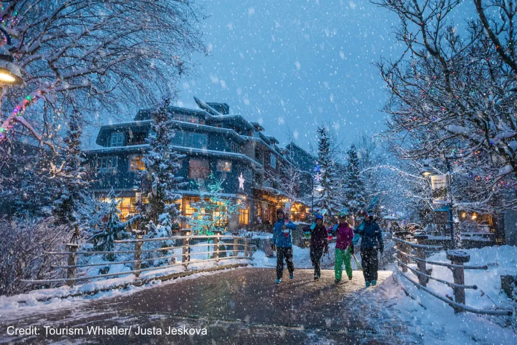 group of people walking in a snowy evening at xmas time in Whistler village