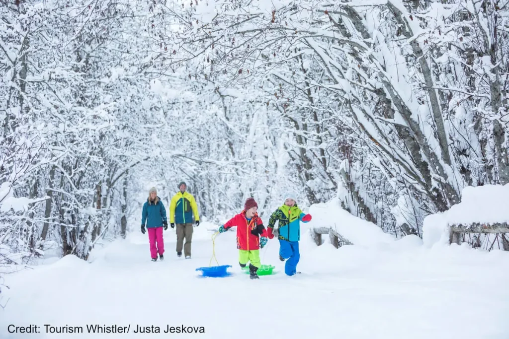 kids pulling a sled through the snow in Whistler