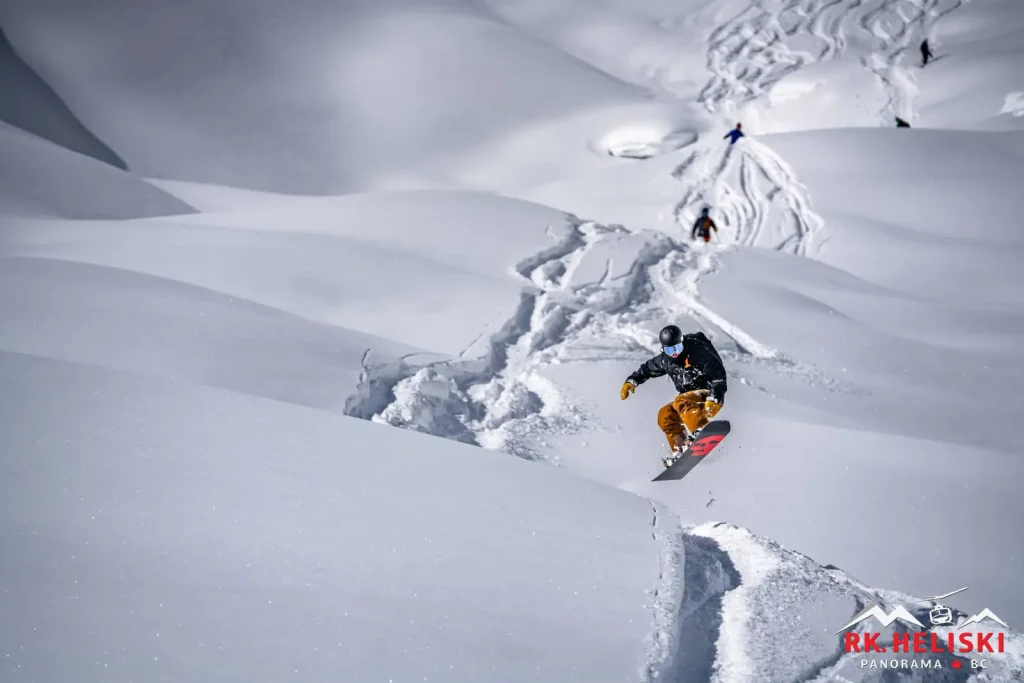 snowboarder catching air and fresh track with RK Heli Ski